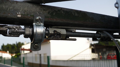 Vêem-se as porcas soldadas aos roletes que se deslocam na calha. Naqueles estão fixas as extremidades do cabo de aço, o qual está preso e enrolado do mastro principal. Funciona 5*